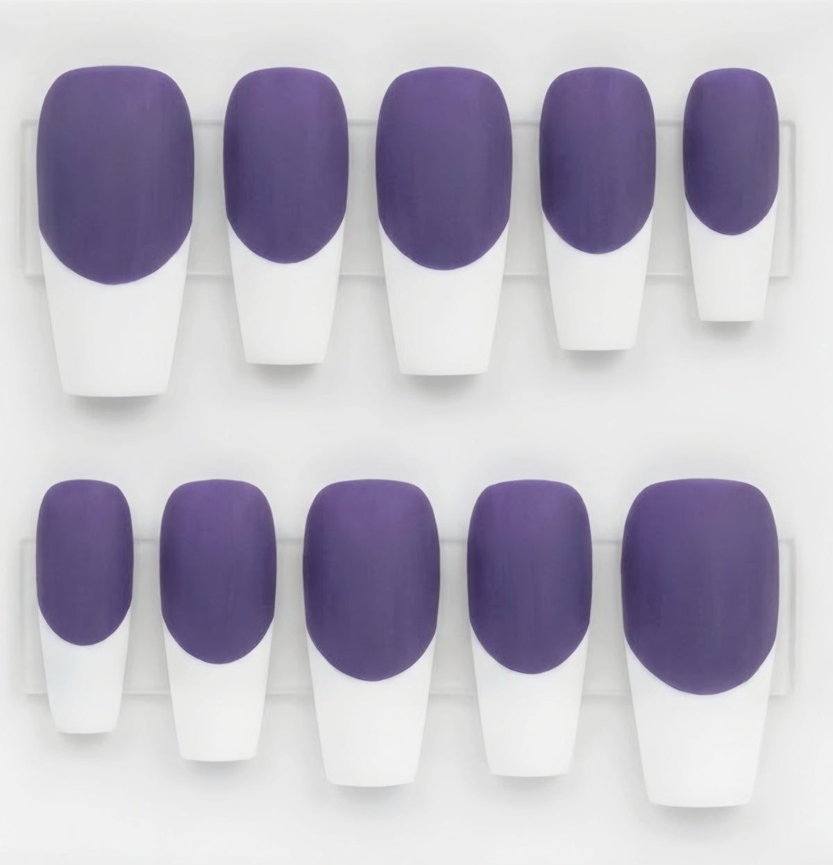 Ten square-shaped press-on nails arranged in two rows on a clear display card, featuring a solid purple top half and a white french tip.