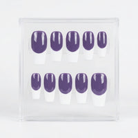 A set of ten press-on nails displayed in a clear acrylic case, featuring a dark purple base and a white French tip.