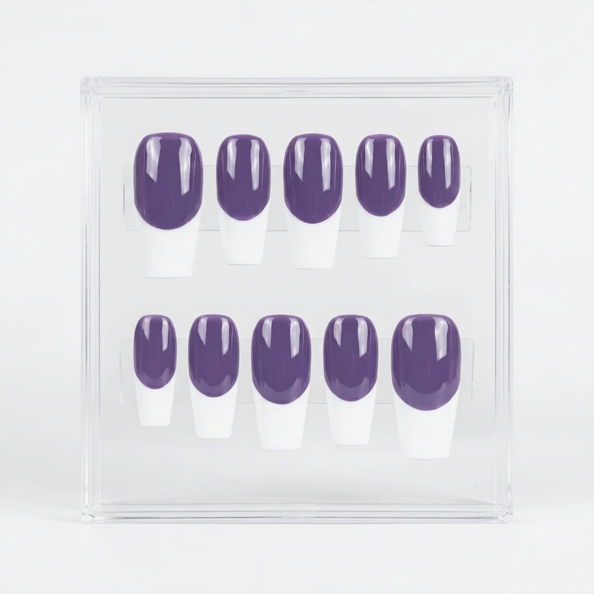 A set of ten press-on nails displayed in a clear acrylic case, featuring a dark purple base and a white French tip.