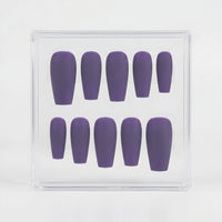A set of ten matte purple press-on nails arranged in two rows inside a clear plastic display box, photographed against a clean white background.