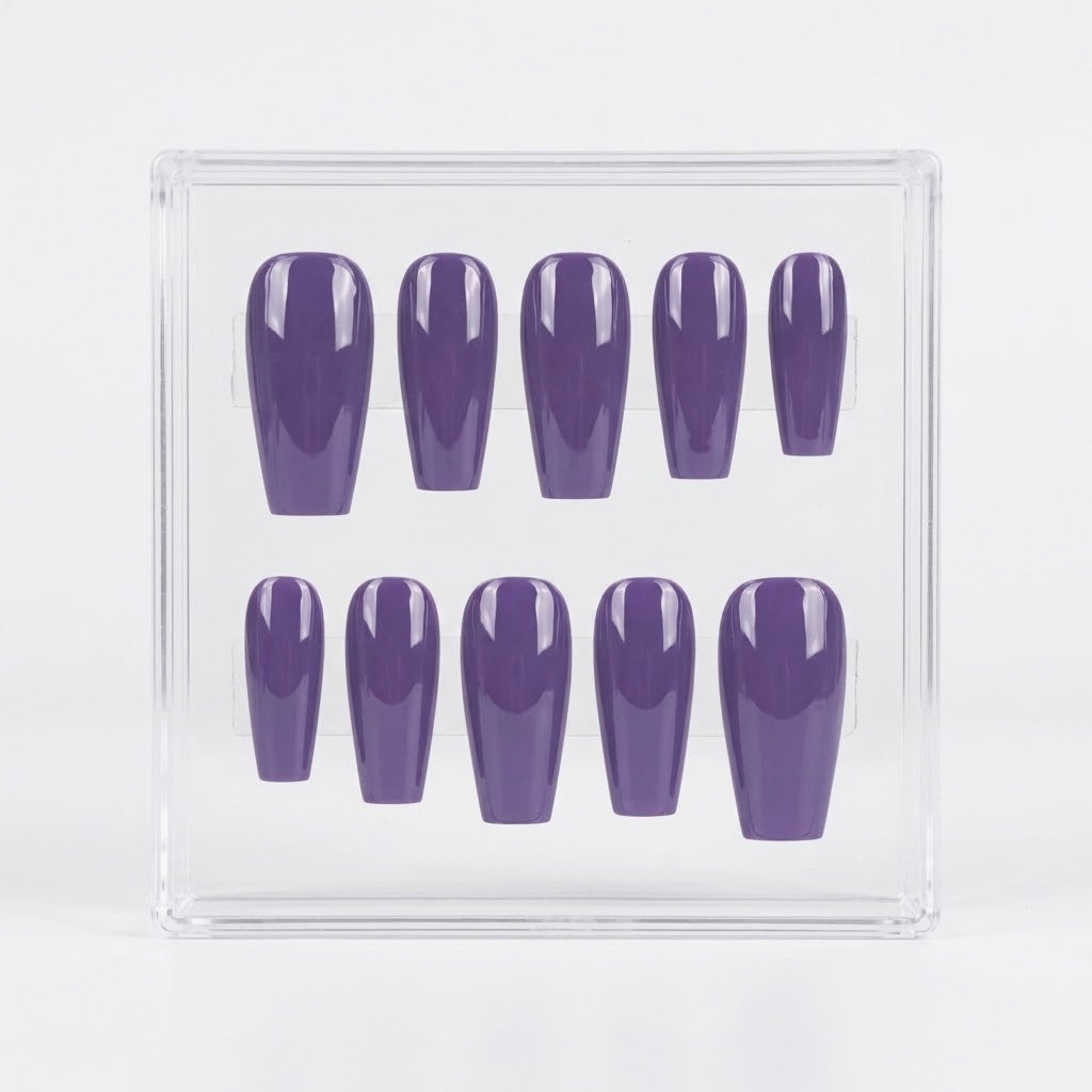 A set of ten glossy purple press-on nails arranged inside a clear plastic display box on a white background.
