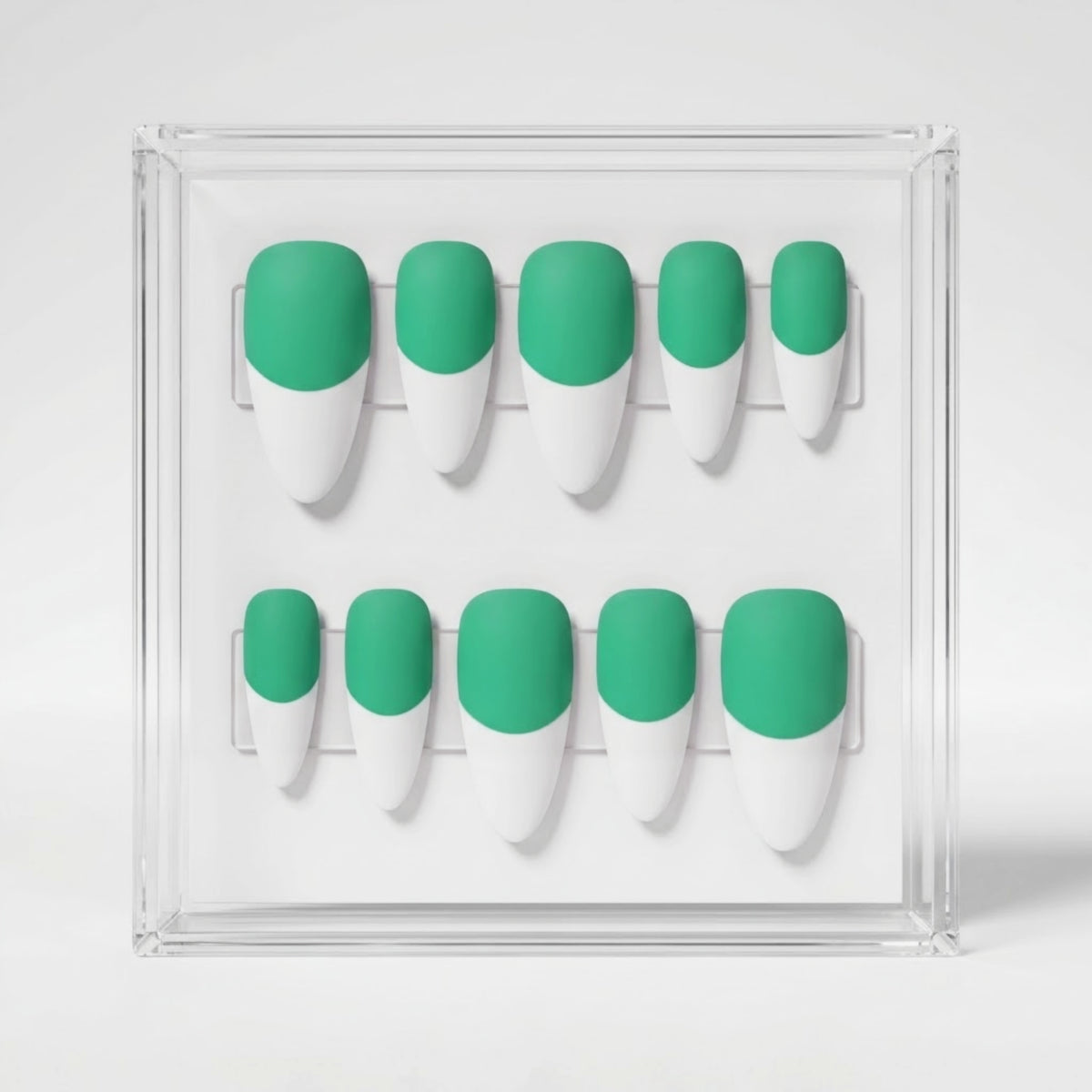 A set of ten false press-on nails displayed in a clear acrylic case, featuring a two-tone design with a matte mint green base and white french tips.