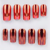 Ten press-on nails with a metallic chrome,  copper-orange finish, arranged in two rows on clear plastic display stands against a white background.