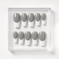 A set of ten press-on nails in a clear plastic tray, featuring a classic gray and white French tip design.