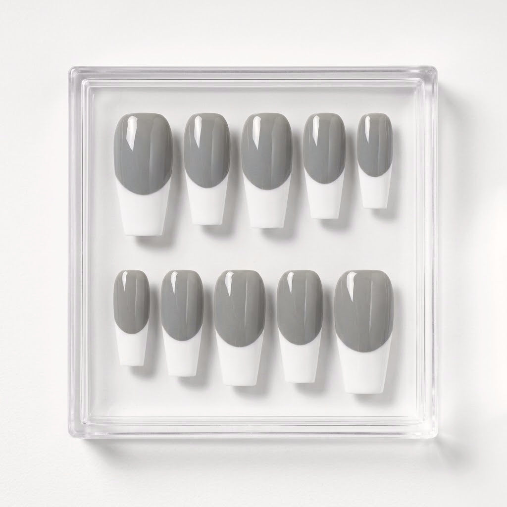 A set of ten press-on nails in a clear plastic tray, featuring a classic gray and white French tip design.