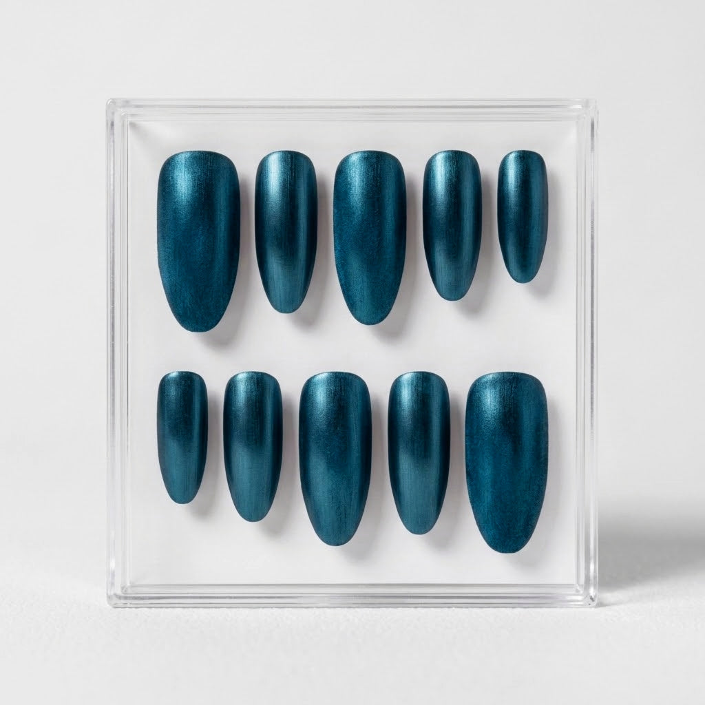 A set of ten metallic teal press-on nails displayed in a clear acrylic case against a light gray background.