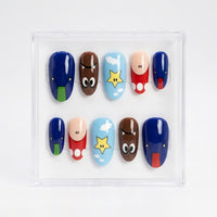 A set of 10 glossy press-on nails arranged in a clear plastic display box. The nails feature cartoon character designs including blue, brown, red, light blue, beige, and yellow details.