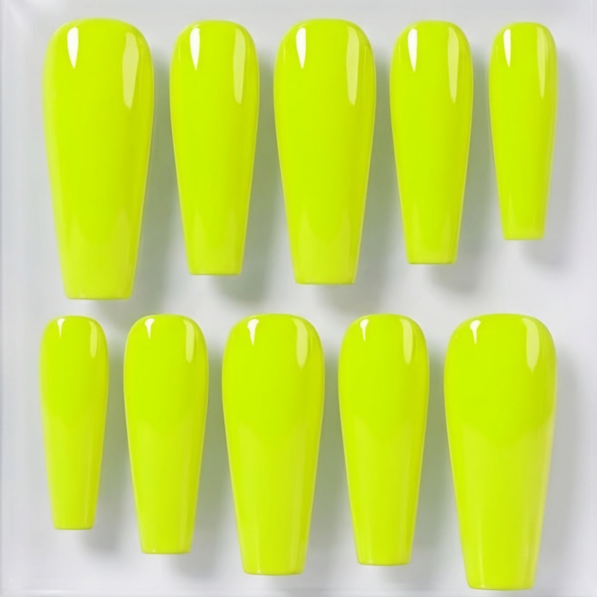 Ten bright neon yellow press-on nails arranged in two rows on a plain white background.