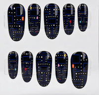 Ten black pac-man themed oval press-on nails with a blue and white retro video game maze pattern, displayed on a clear plastic hanger against a white background.