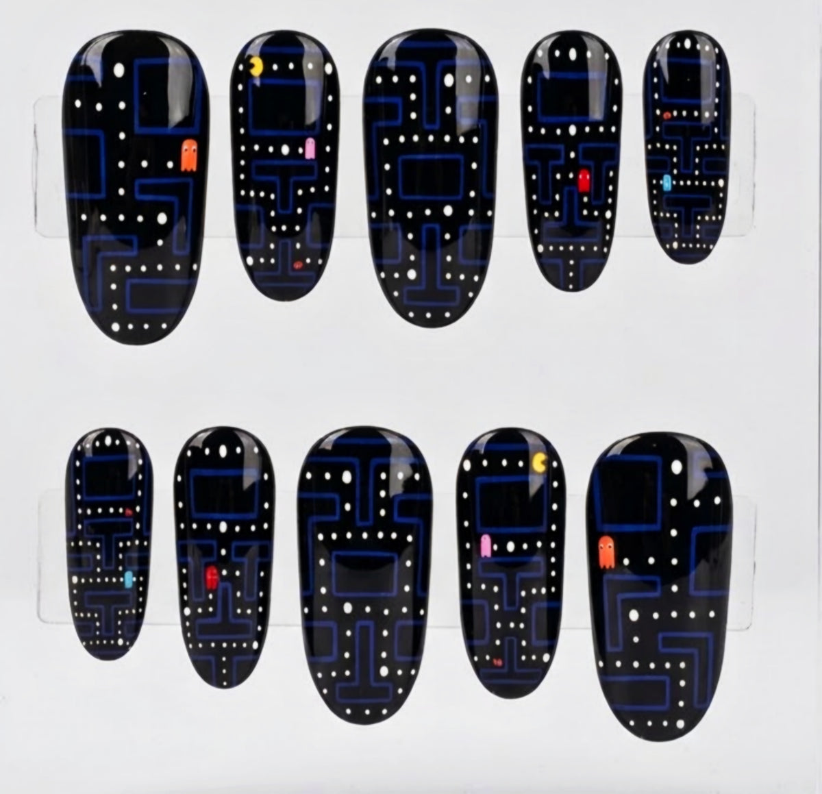 Ten black pac-man themed oval press-on nails with a blue and white retro video game maze pattern, displayed on a clear plastic hanger against a white background.