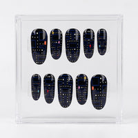 A set of ten glossy Pac-man themed press-on nails displayed inside a clear acrylic case on a white background. The nails are glossy black with a blue maze pattern, white dots, and small red and pink accents, mimicking a retro video game theme.