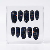 A set of ten matte Pac-man themed press-on nails displayed inside a clear acrylic case, featuring a dark blue and black retro video game maze pattern with small colorful dots.