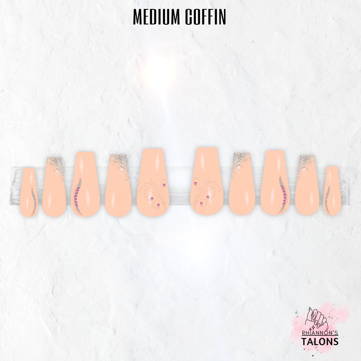 Peach Stardust peach press-on nails with silver glitter, swirl nail art, pink crystal accents and glossy long coffin false nails.