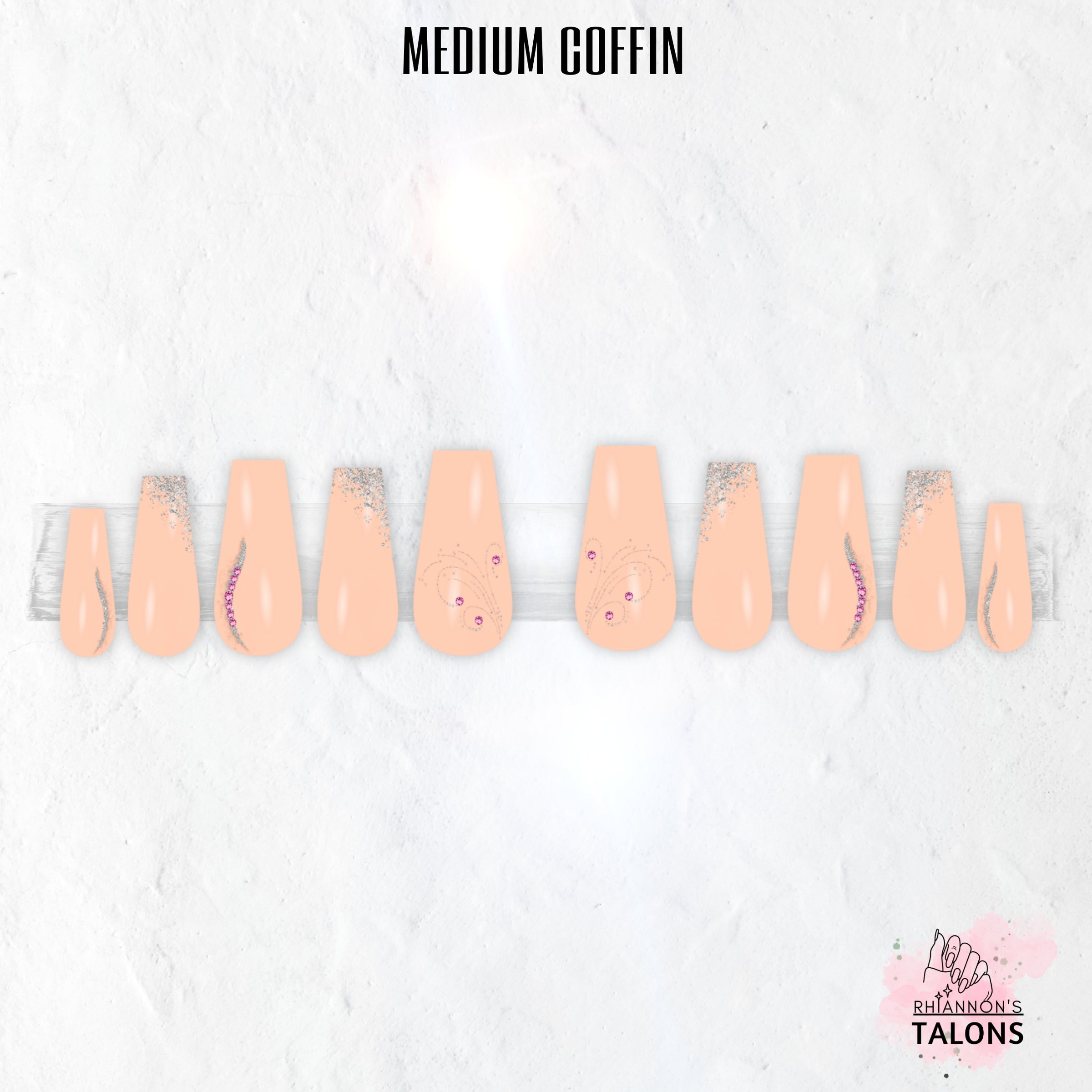 Peach Stardust peach press-on nails with silver glitter, swirl nail art, pink crystal accents and glossy long coffin false nails.