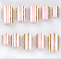 Ten square press-on nails arranged in two rows on a clear plastic display card against a white background. The nails feature vertical stripes in light pink, white, and metallic gold glitter.