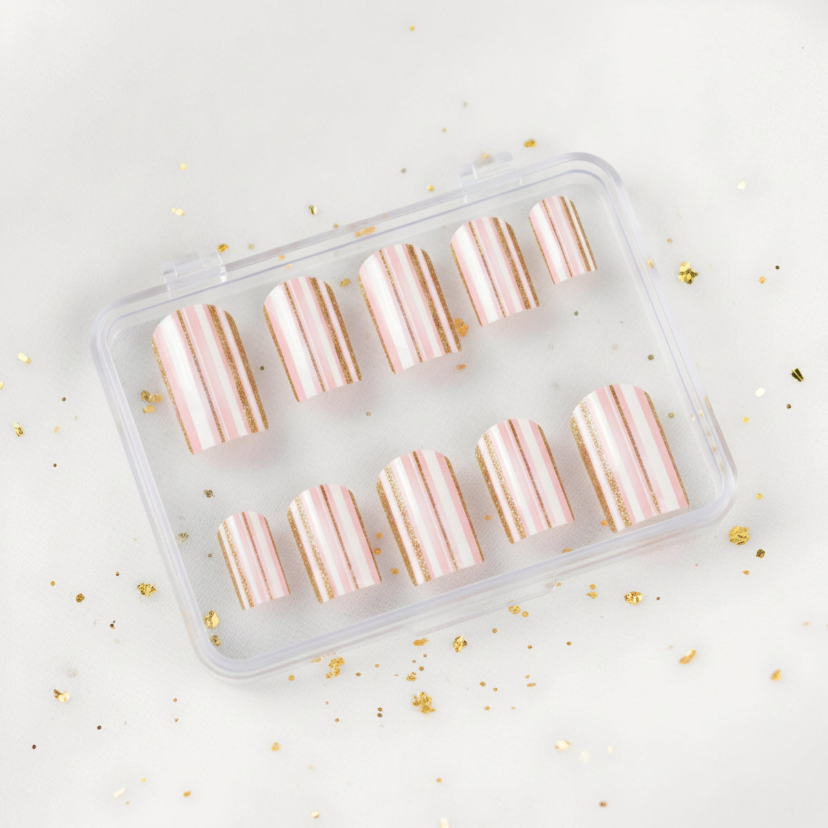 Pretty Little Lines pink and white press-on nails with gold stripe nail art