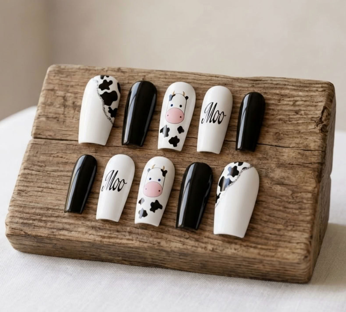 Moo-tiful black and white cow print press-on nails with cute animal nail art