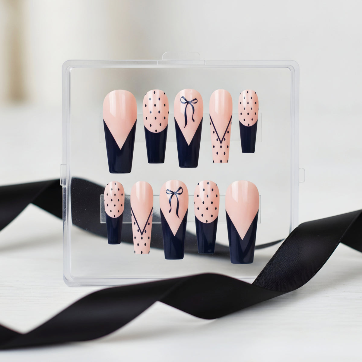 Polka Dot Passion black and pink press-on nails with polka dots and bow nail art