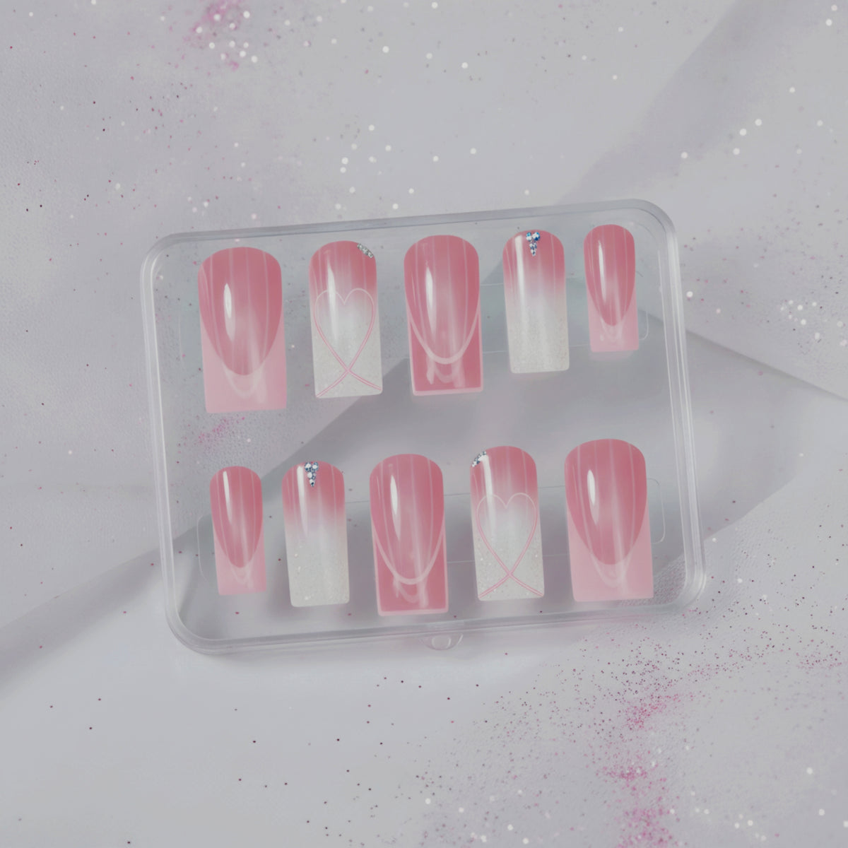 Sweetheart pink press-on nails with heart nail art, glitter and crystal accents