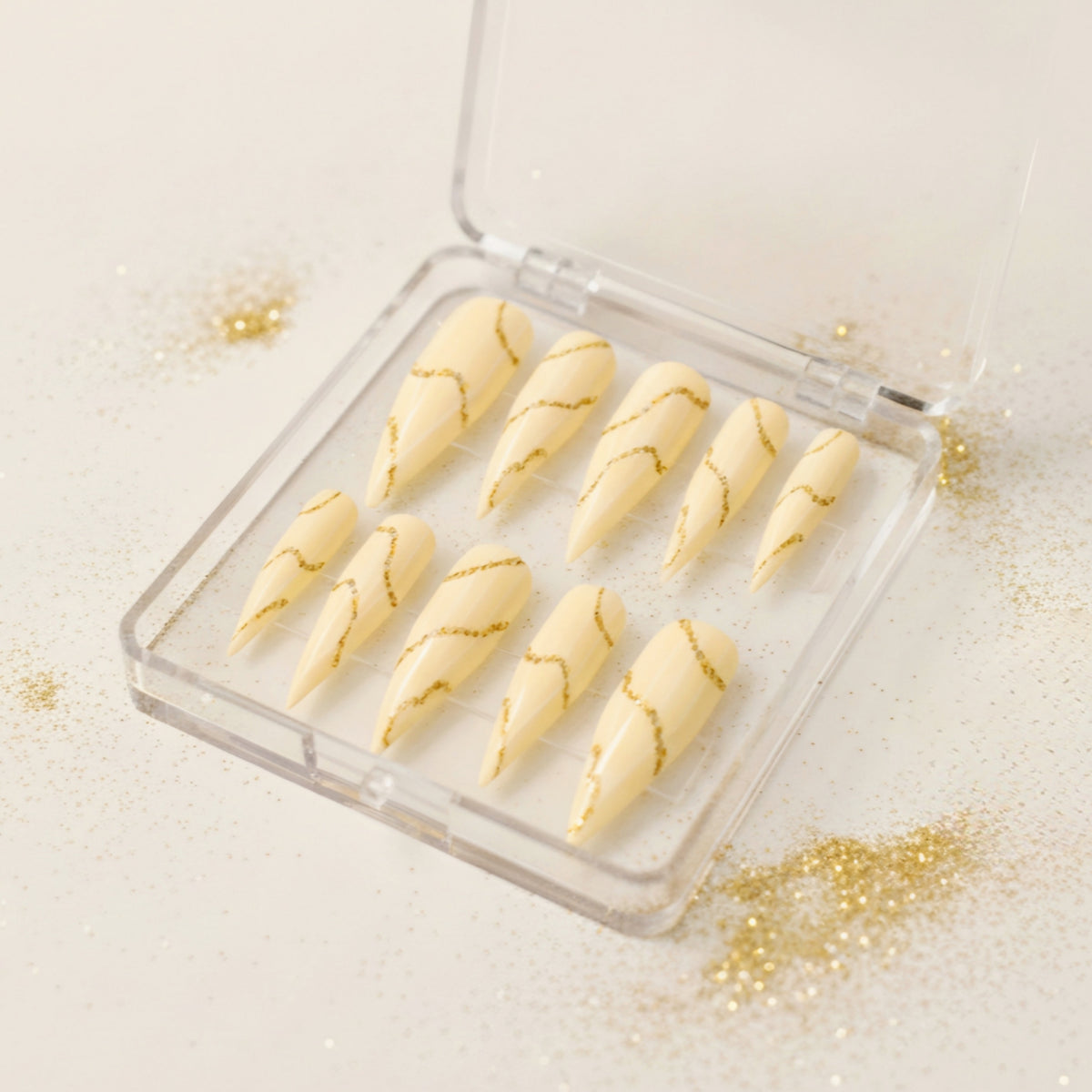 Golden Ripple cream press-on nails with flowing gold glitter wave nail art