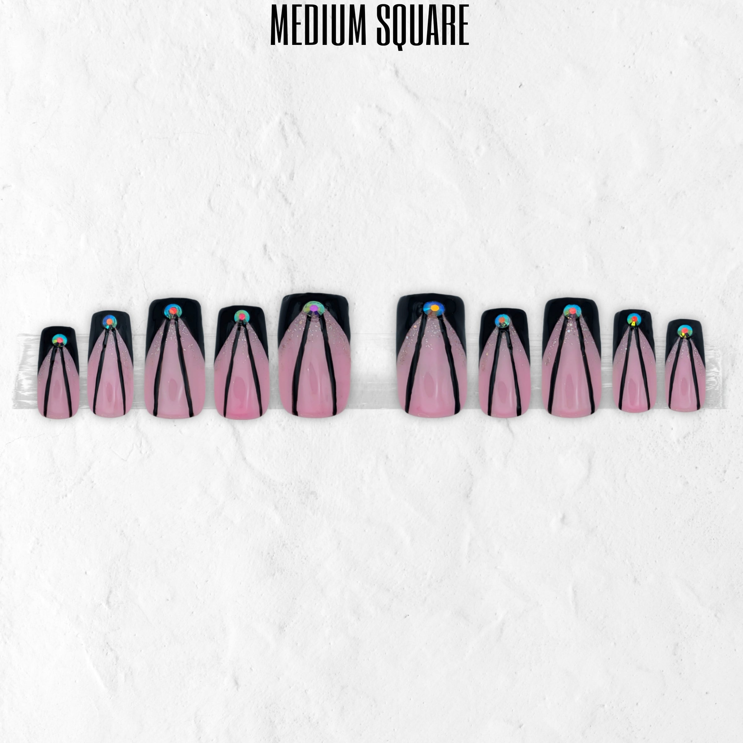 Pink Cut pink and black press-on nails with sharp V-cut line nail art, glitter accents and glossy medium square false nails.
