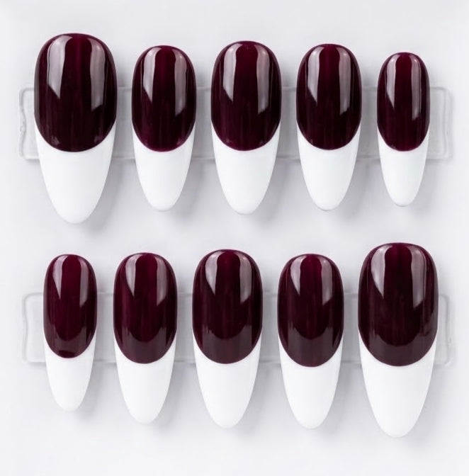 A set of ten press-on nails arranged in two rows of five on a clear plastic display card, featuring a glossy dark burgundy base and a white french tip.