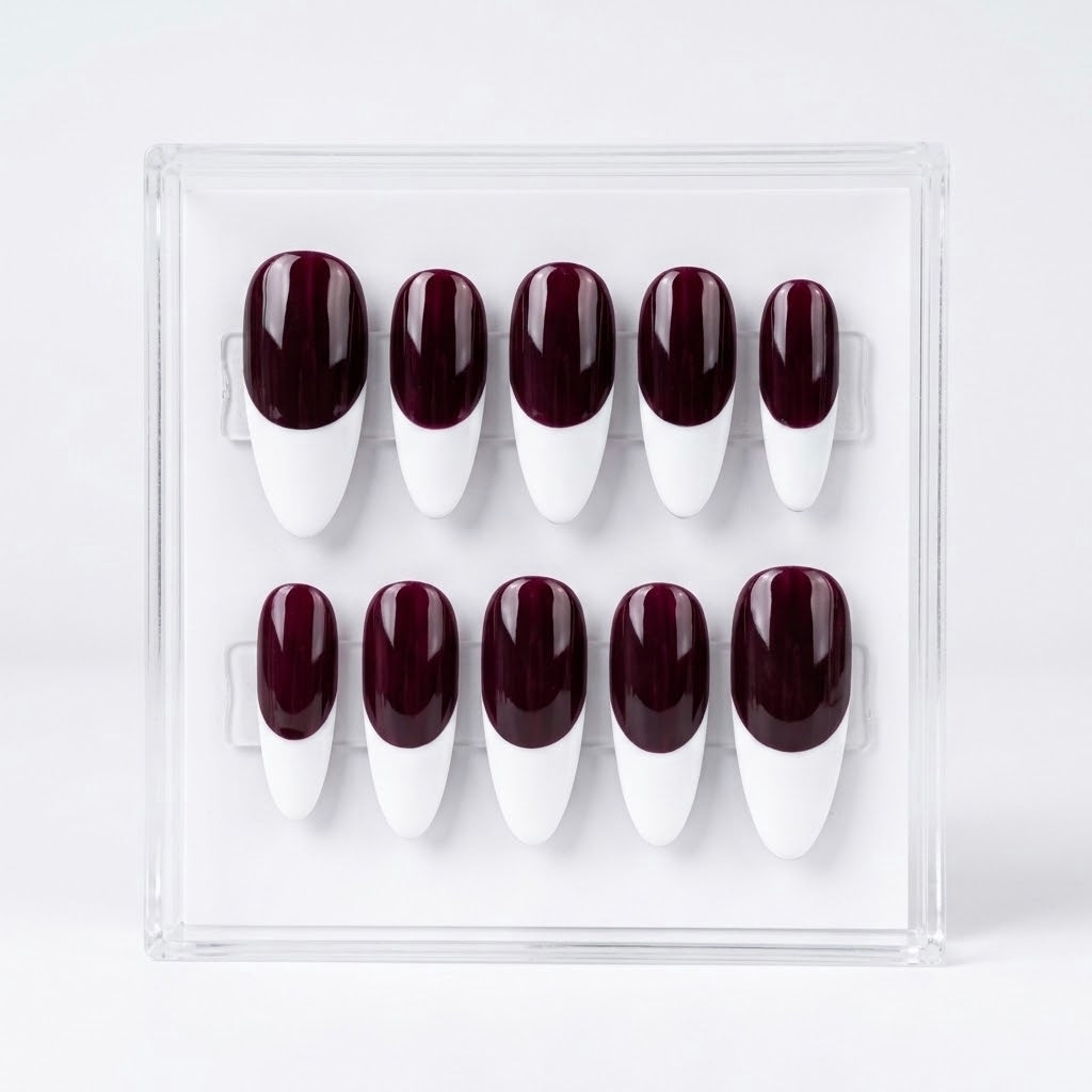 A set of ten false press-on nails displayed in a clear acrylic case against a white background. The nails feature a glossy deep burgundy base and a white  French manicure design.
