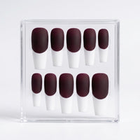 A set of ten press-on nails displayed in a clear acrylic case against a light gray background. The nails feature a matte deep burgundy base and a white  french tip.