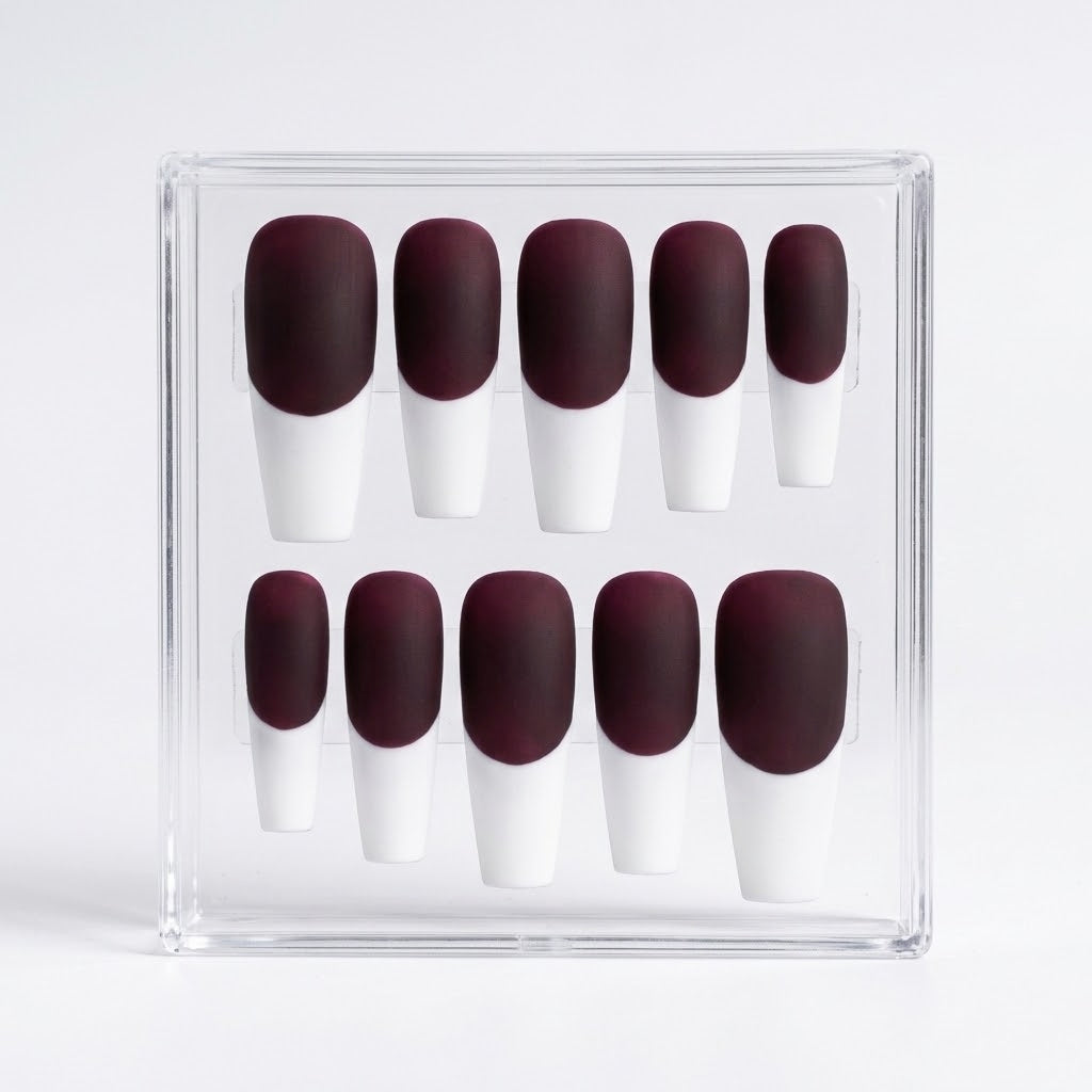 A set of ten press-on nails displayed in a clear acrylic case against a light gray background. The nails feature a matte deep burgundy base and a white  french tip.