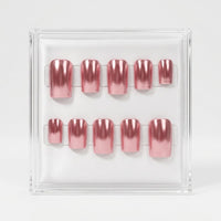 A set of 10 press-on nails light pink metallic chrome colour, displayed in a clear acrylic case against a light gray background.