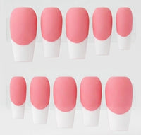 A set of false press-on nails arranged in two rows on a white display. Each nail has a soft pink base and white french tips.