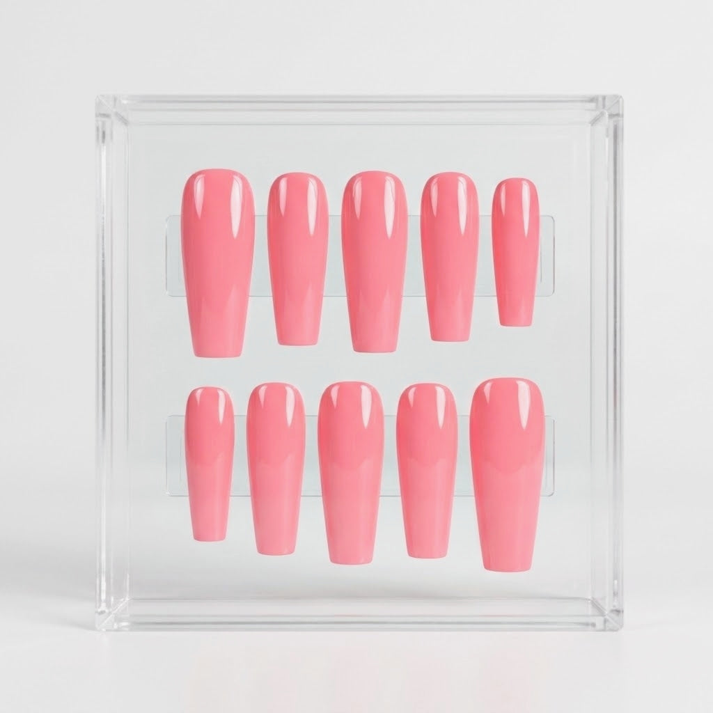 A set of glossy pink press-on nails arranged in two rows inside a clear acrylic display box on a light gray background.