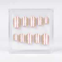 A set of ten square press-on nails with vertical metallic rose gold and gold stripes, displayed inside a clear acrylic case on a white background.