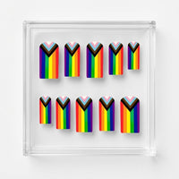 A set of 10 square matte press on nails featuring a rainbow pride flag. Displayed on a clear display case on a white background.