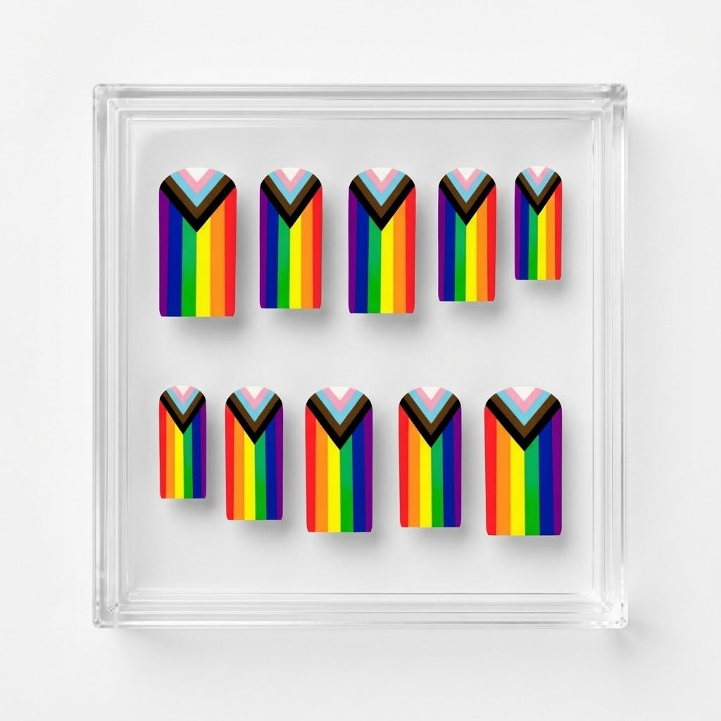 A set of 10 square matte press on nails featuring a rainbow pride flag. Displayed on a clear display case on a white background.