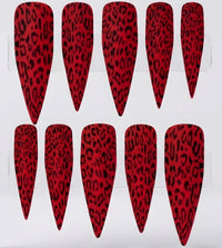 Ten matte red stiletto-shaped press-on nails with a black leopard print pattern, arranged in two rows on a white background.