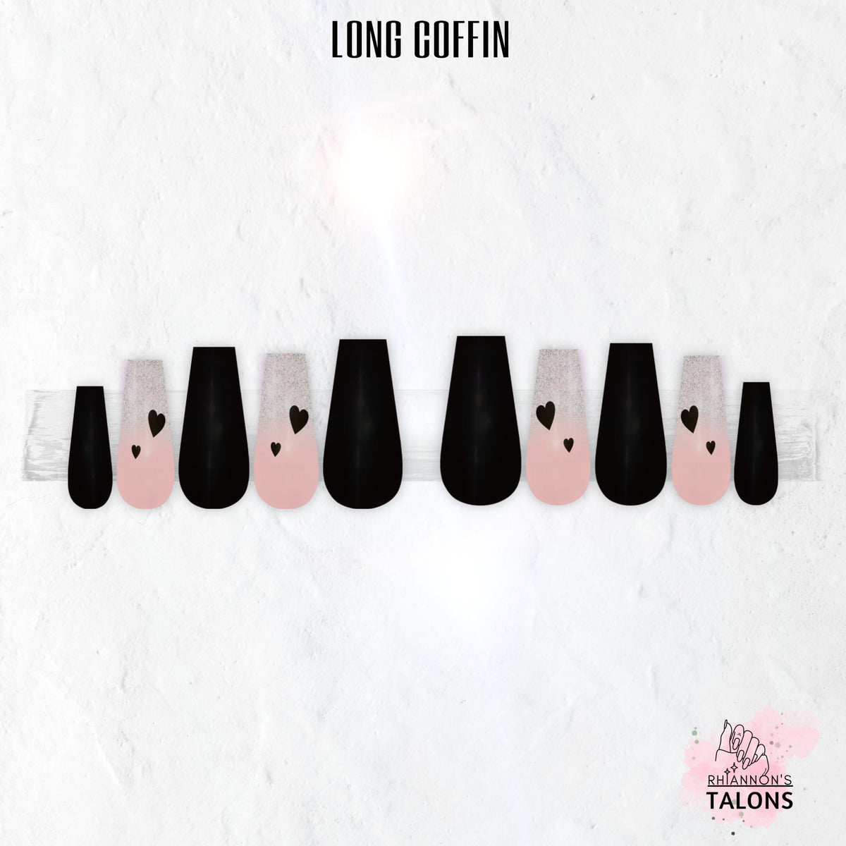 Glossy black and pink press-on nail set named Secret Admirer, featuring black nails, blush pink glitter ombré accent nails, and black heart nail art in a long coffin shape.