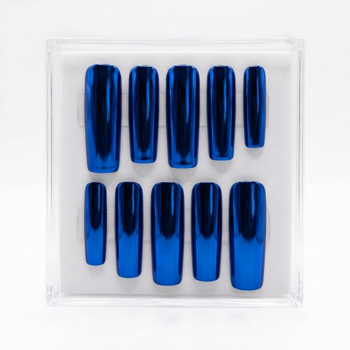 A set of ten metallic royal blue chrome press-on nails arranged in two rows inside a clear plastic display box on a white background.