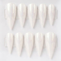 Ten white stiletto press-on nails with a subtle iridescent shimmer, arranged in two rows on a clear plastic display card against a white background.