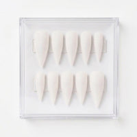Ten shimmery matte white stiletto-shaped press-on nails arranged in two rows inside a clear plastic display case on a white background. 