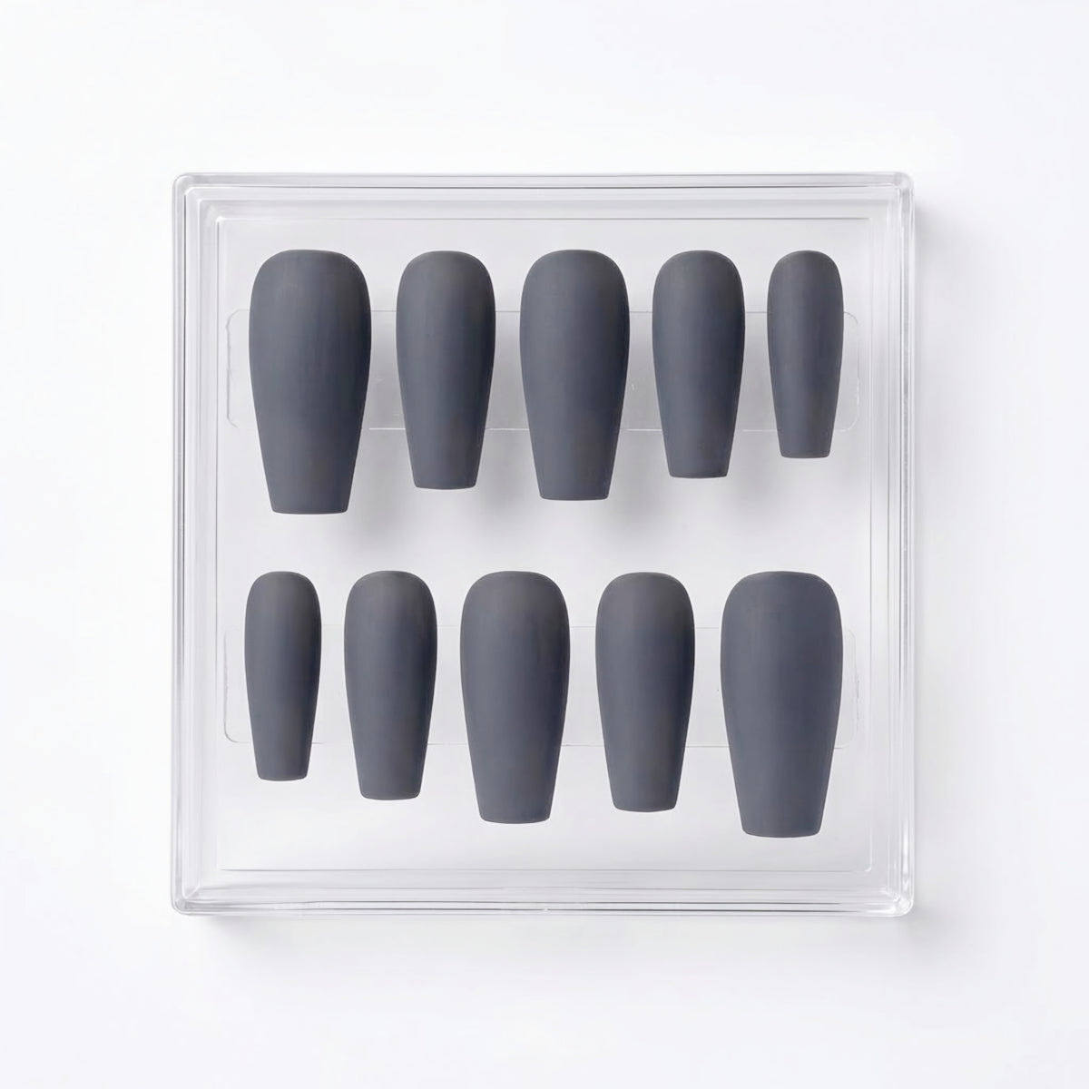 A set of ten matte dark gray press-on nails arranged in a clear plastic display box on a white background.