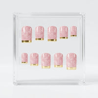 Ten square pink glitter press on nails with chrome gold tips, arranged in two rows on a plain white background.