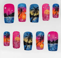 Ten square nail tips displayed in two rows on a white background, featuring tropical sunset designs with palm trees, colorful gradients, glitter, and splatter details.