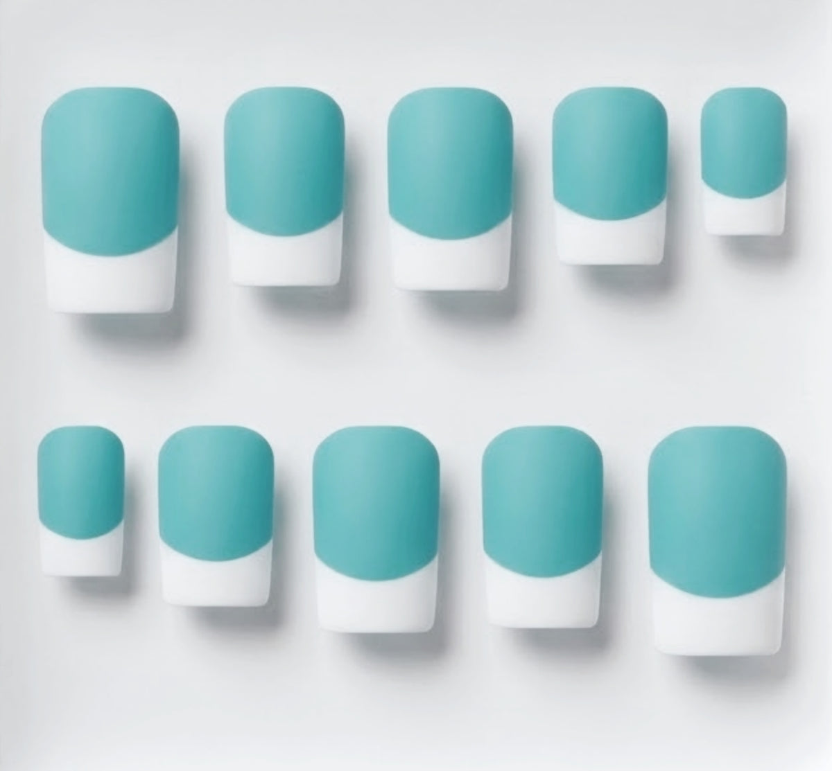 Ten French manicure nail tips arranged in two rows on a light gray background, featuring a solid light blue/turquoise base and white french tips.