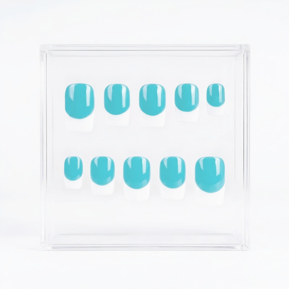 A set of ten press-on nails with a glossy turquoise blue base and french tips, displayed inside a clear acrylic square box on a white background.
