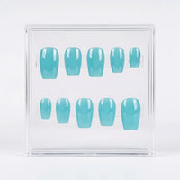 A set of ten press-on nails in a glossy light aqua blue color, displayed inside a clear acrylic case on a white background.