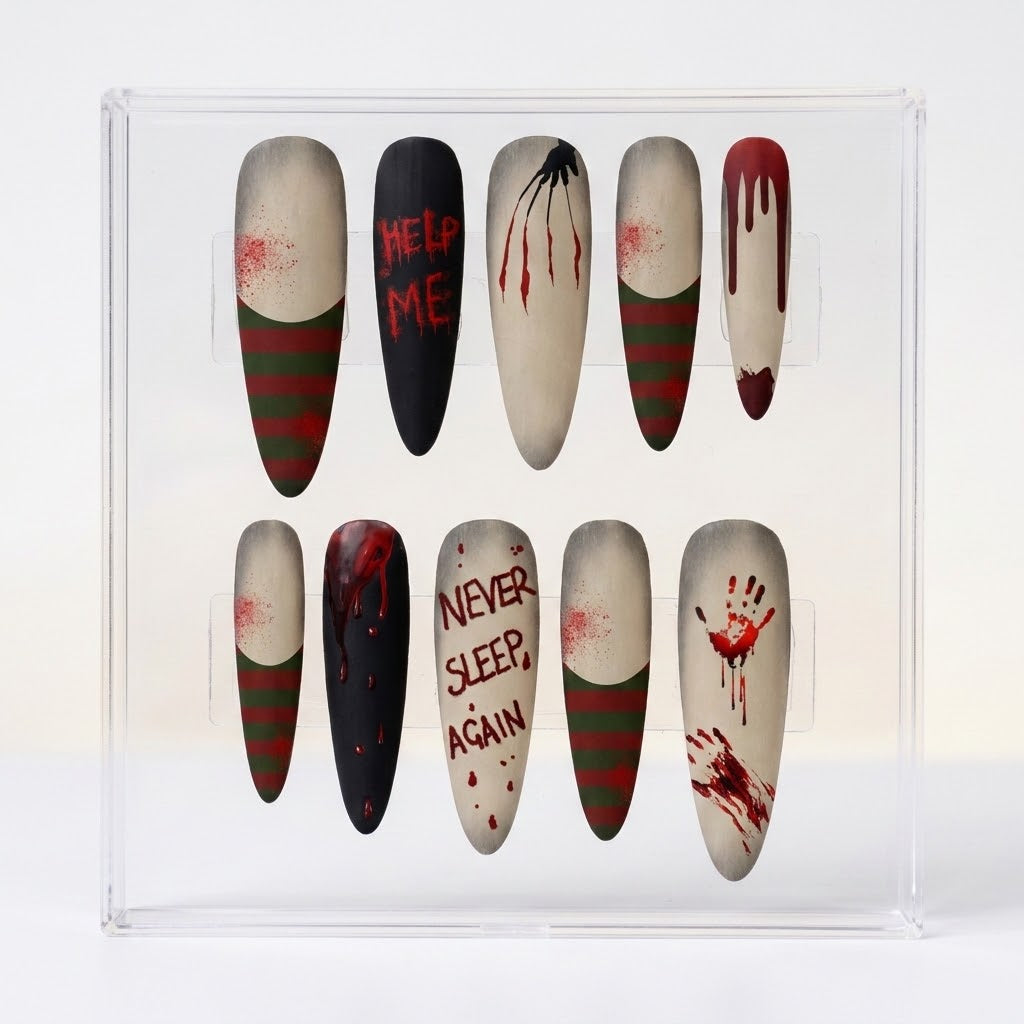 A set of almond press-on nails displayed in a clear plastic case, featuring horror movie themed designs with red blood splatters, green and red horizontal stripes, and text reading 'HELP ME', 'NEVER SLEEP AGAIN', and 'HELP ME'.