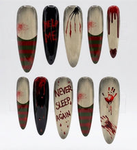 A set of ten almond press-on nails arranged in two rows on a white background. The designs include horror movie graphics such as blood splatters, dripping blood, green and red stripes, a spider on one nail, and text reading 'HELP ME', 'NEVER SLEEP, AGAIN', and a bloody handprint.