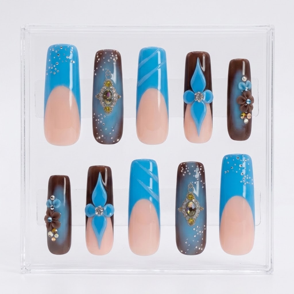 A set of 10 press-on nails displayed in a clear plastic case. The nails feature a split design with a light peach-pink lower half and a bright blue upper half decorated with various patterns including glitter, stripes, floral motifs, and brown gradient sections.