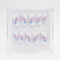 A set of 10 square white glossy press on nails featuring a trans colours themed design. With pink and pale bue ombre swipe and small pink, blue and white flowers with rhinestone centres.